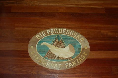 A sign on a wooden floor that says big powderhorn steamboat fantasy