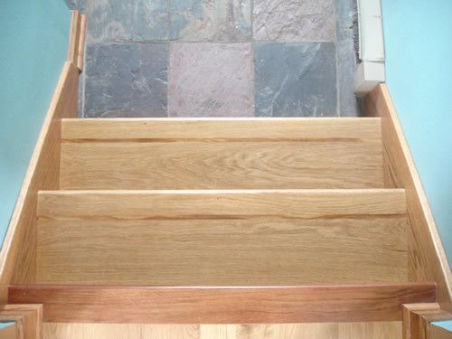 A set of wooden stairs leading up to a tiled floor