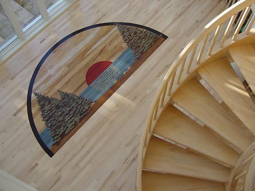 A wooden spiral staircase with a rug on the floor