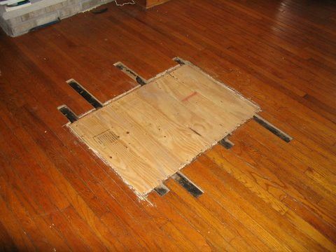 A piece of wood is laying on a wooden floor