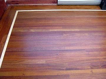 A close up of a wooden floor with a white border.