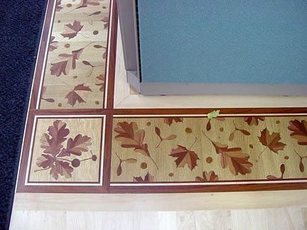 A wooden floor with a pattern of leaves on it