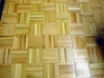 A close up of a wooden floor with square tiles.