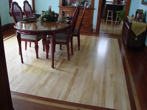 A dining room with a wooden table and chairs