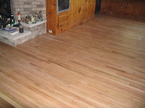 A living room with hardwood floors and a fireplace.