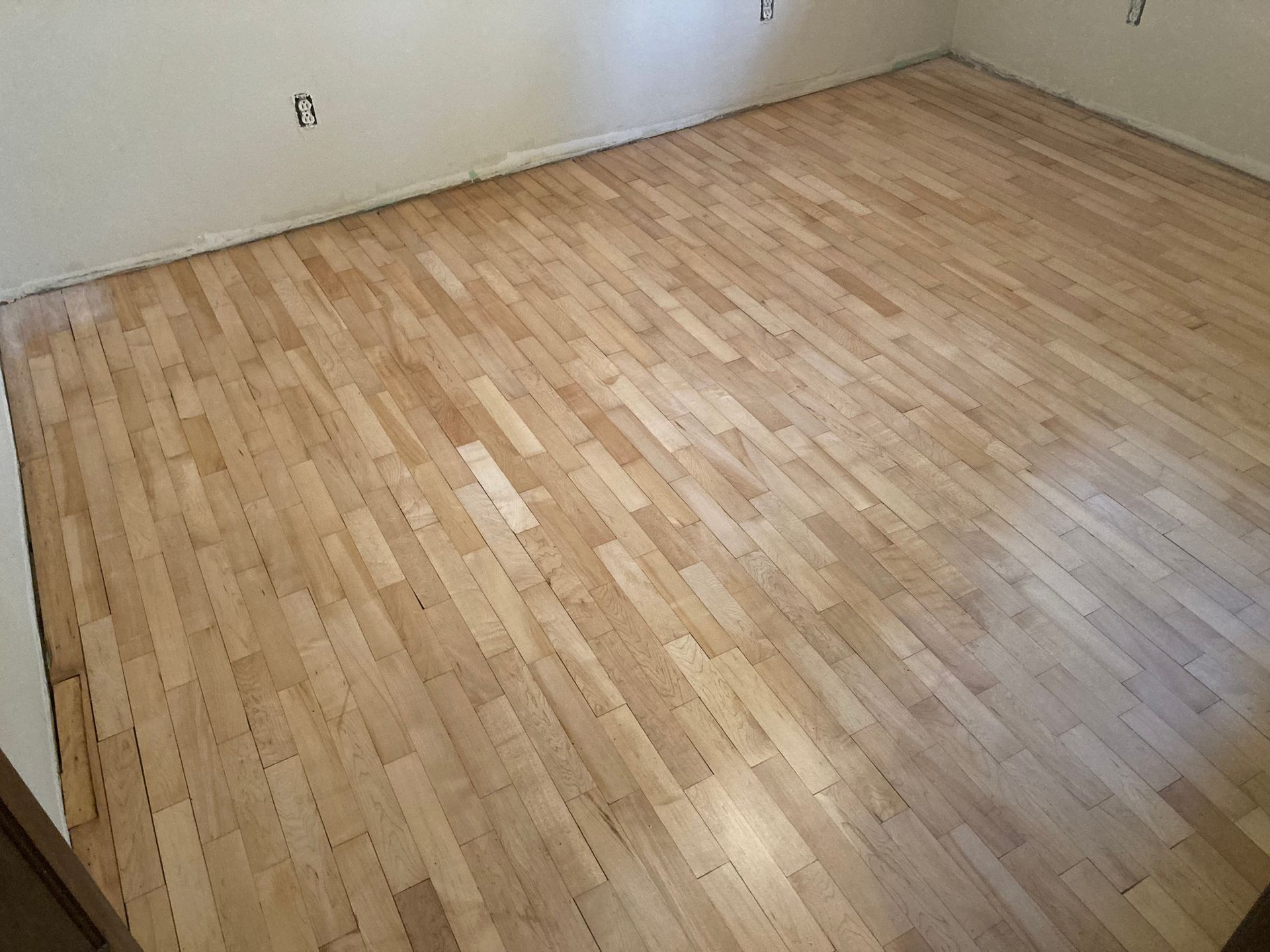 A room with a wooden floor and white walls.