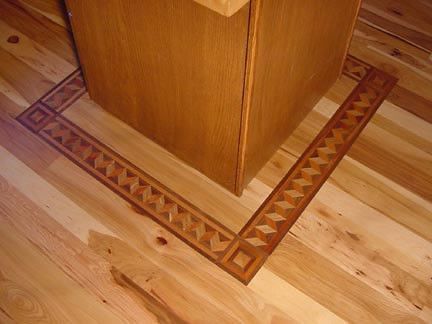 A wooden floor with a wooden border around the corner.