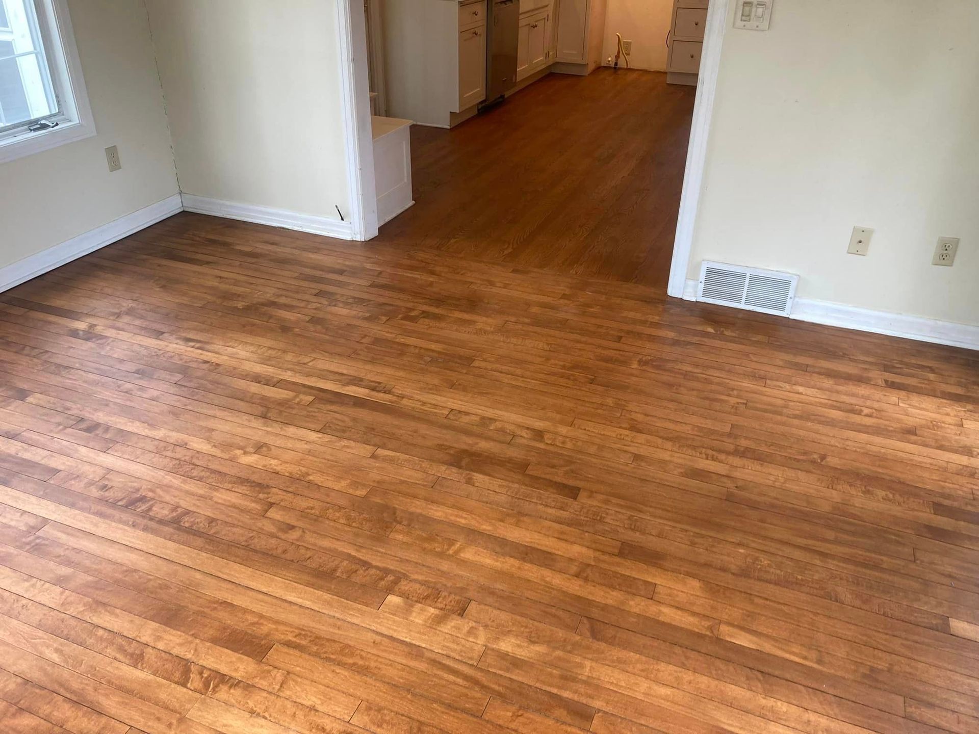 A living room with hardwood floors and a window.