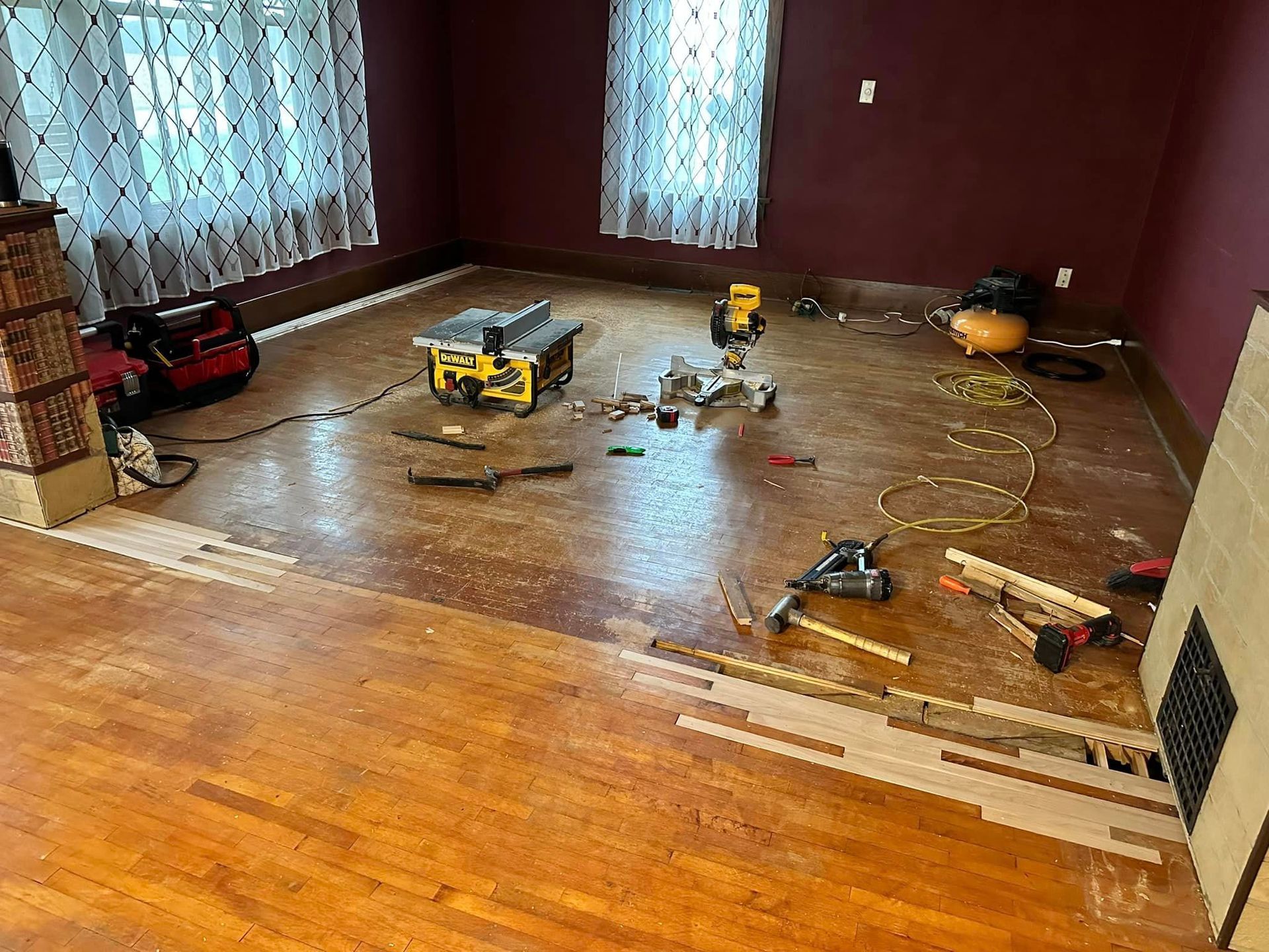 A living room with a lot of tools on the floor and a fireplace.