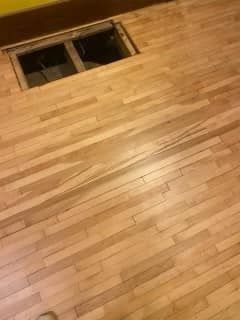 A wooden floor with a hole in the middle of it.
