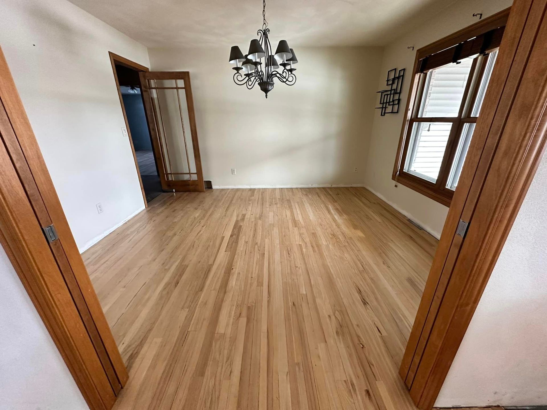 A dining room with hardwood floors and a chandelier