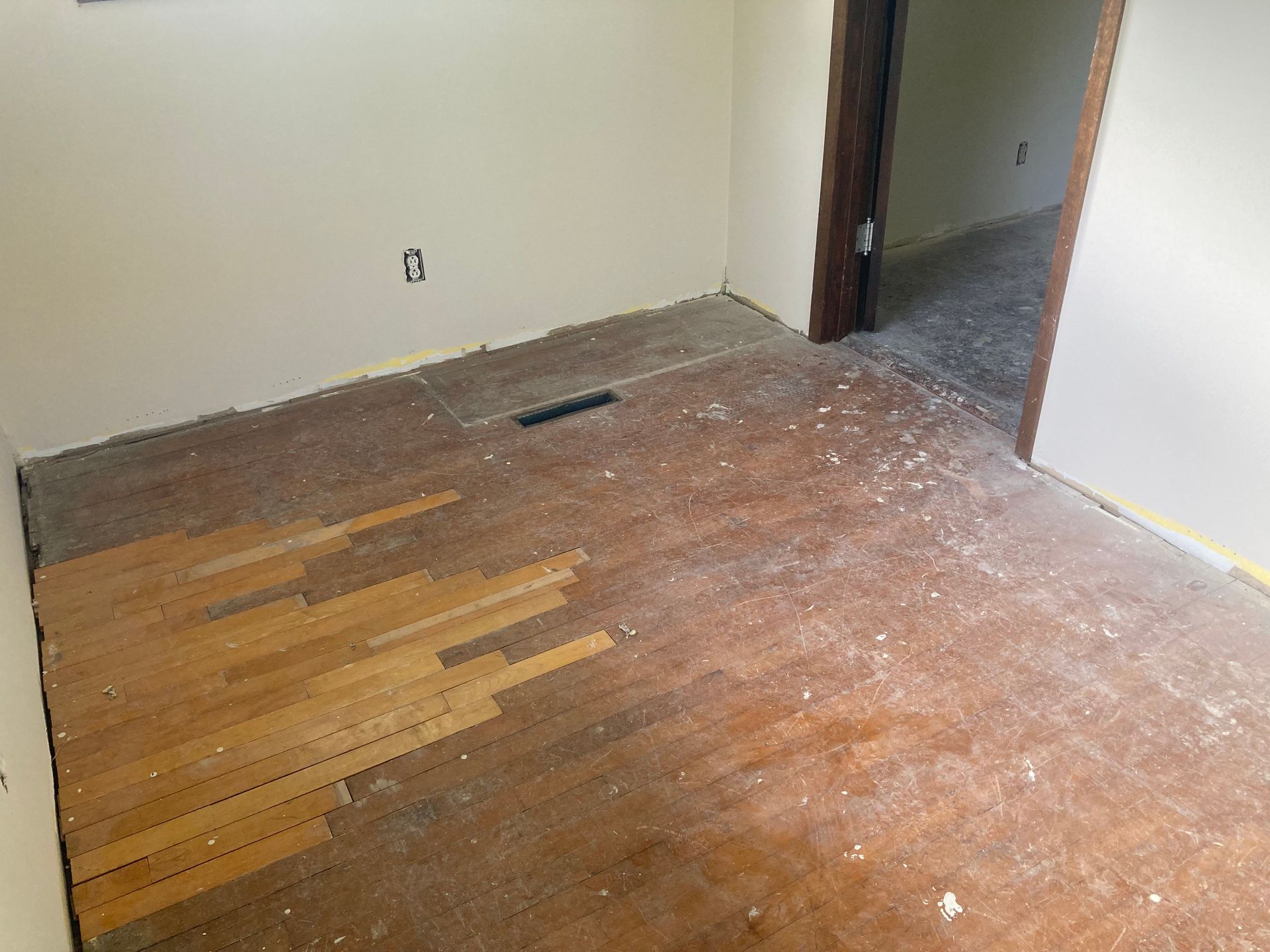 An empty room with a wooden floor and a door.
