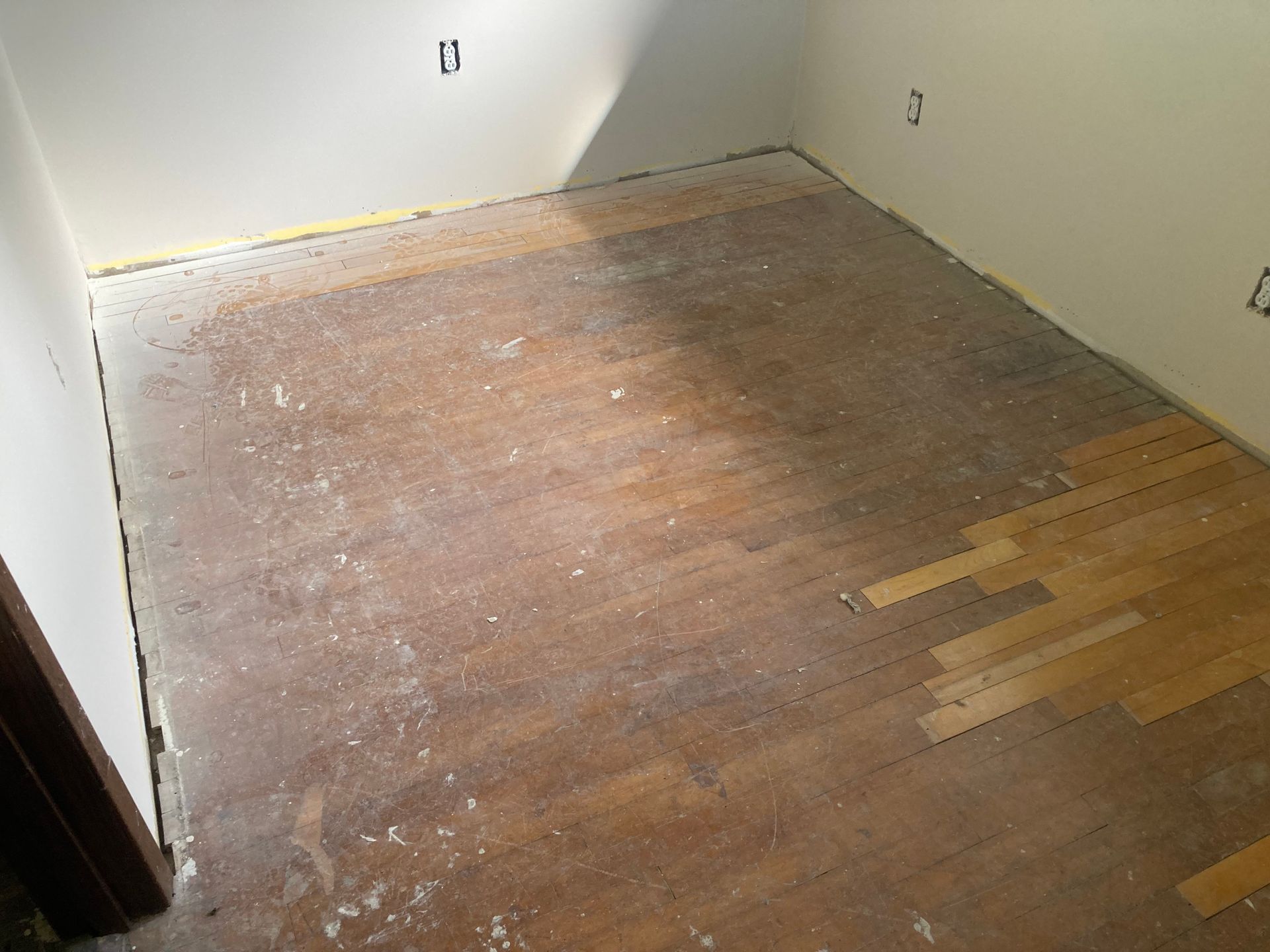 A room with a wooden floor and white walls.