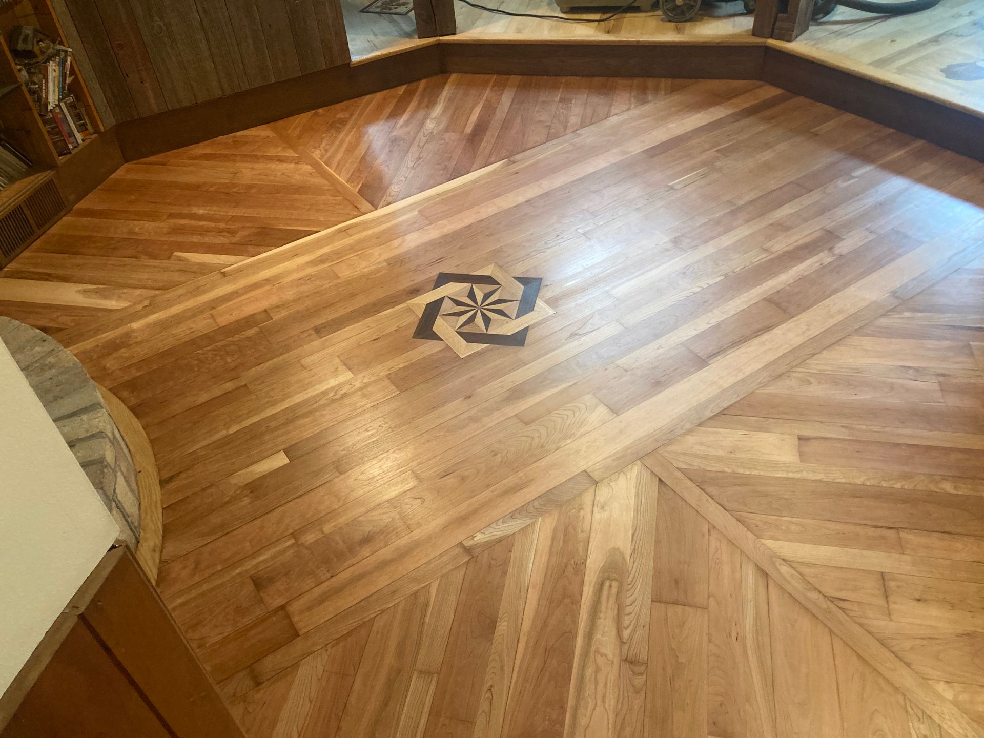 A wooden floor with a pattern on it in a room.
