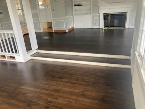 A living room with hardwood floors and a fireplace.