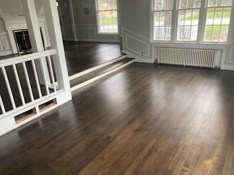 A living room with hardwood floors and a white railing.