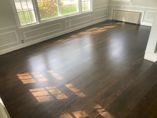 A living room with hardwood floors and a fireplace.