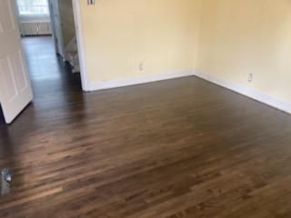 An empty room with hardwood floors and yellow walls.