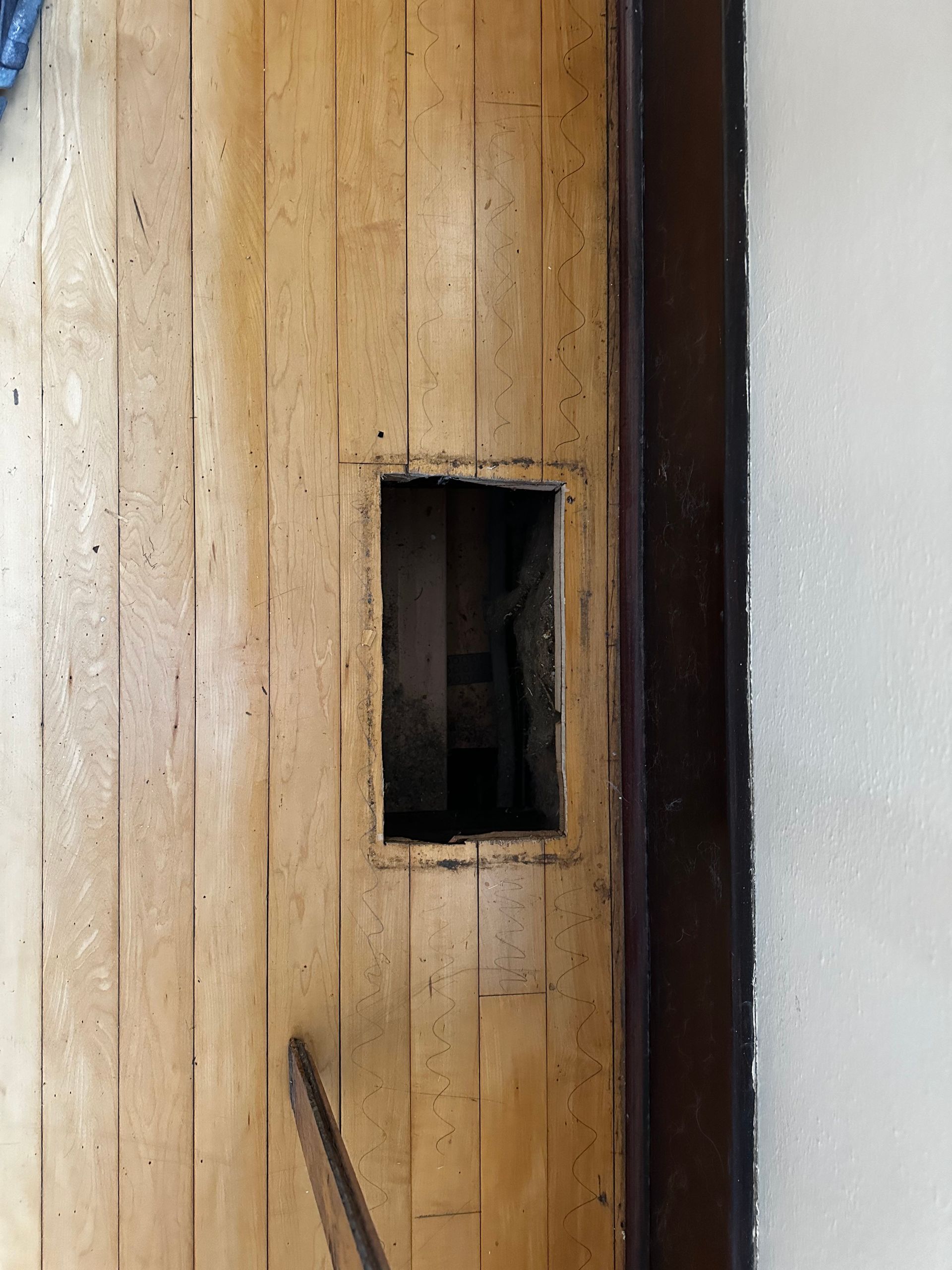 A wooden door with a hole in the middle of it.