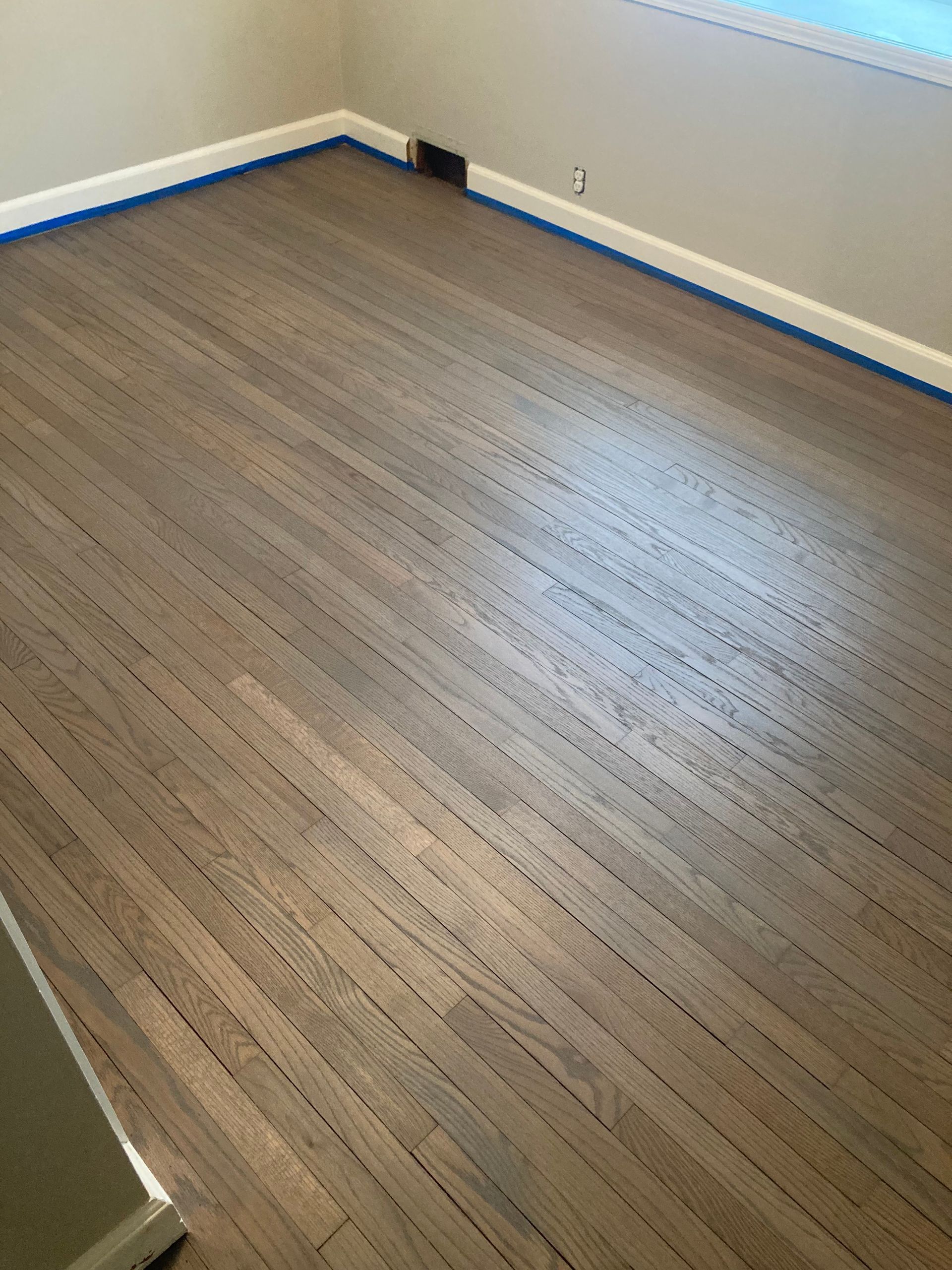 A room with a wooden floor and a window.