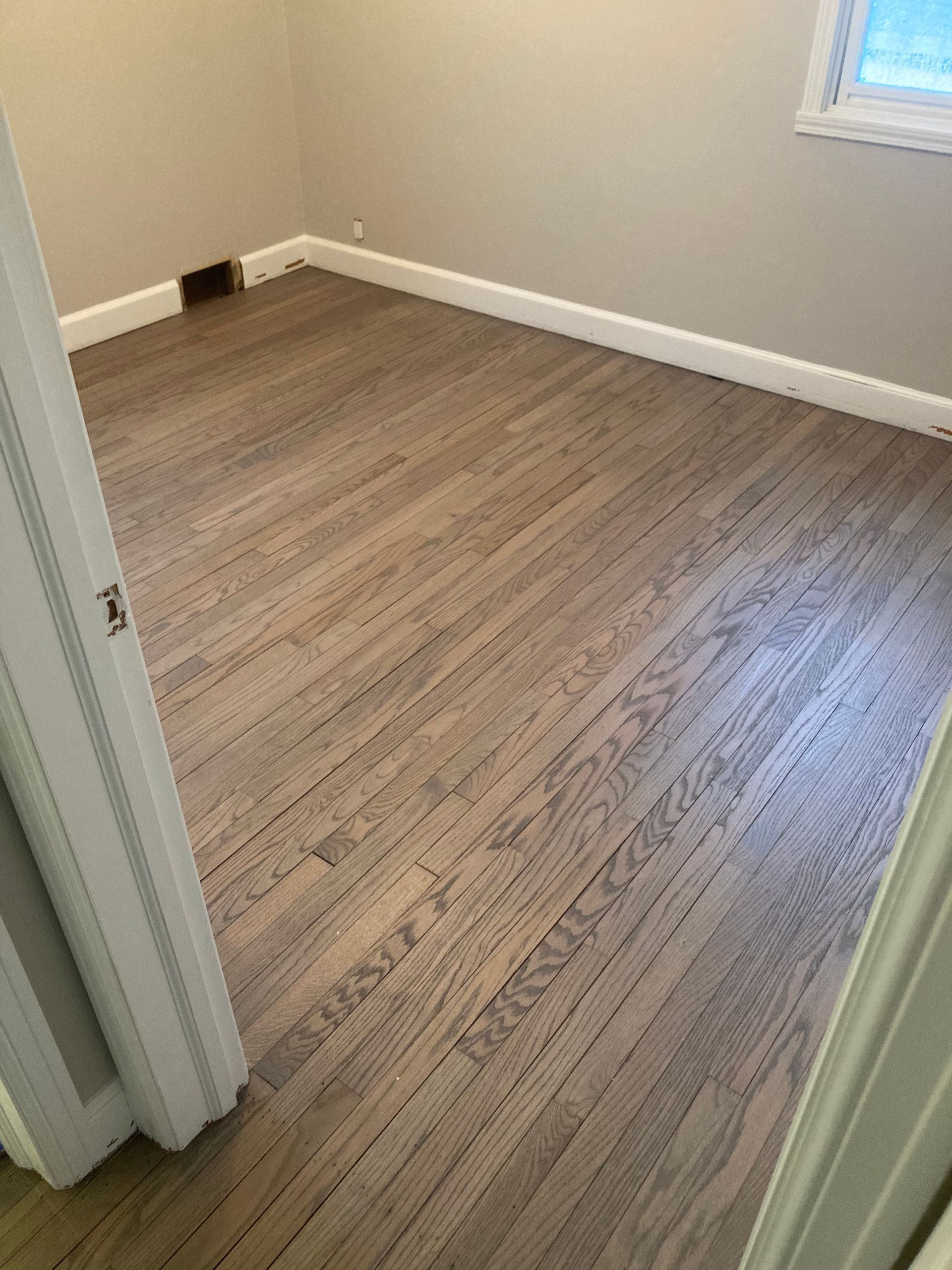 A room with a wooden floor and white trim.