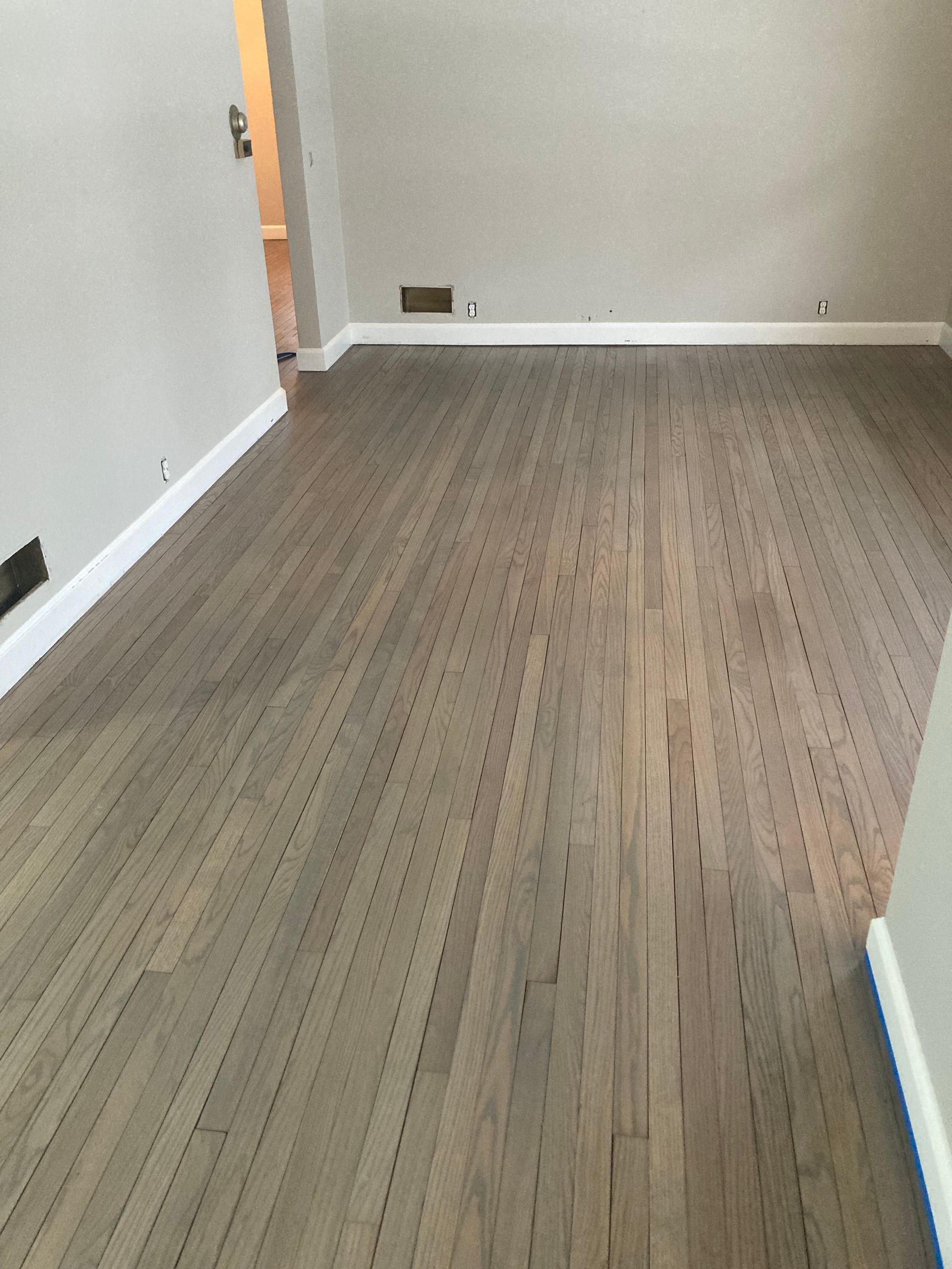 A living room with a wooden floor and white trim.