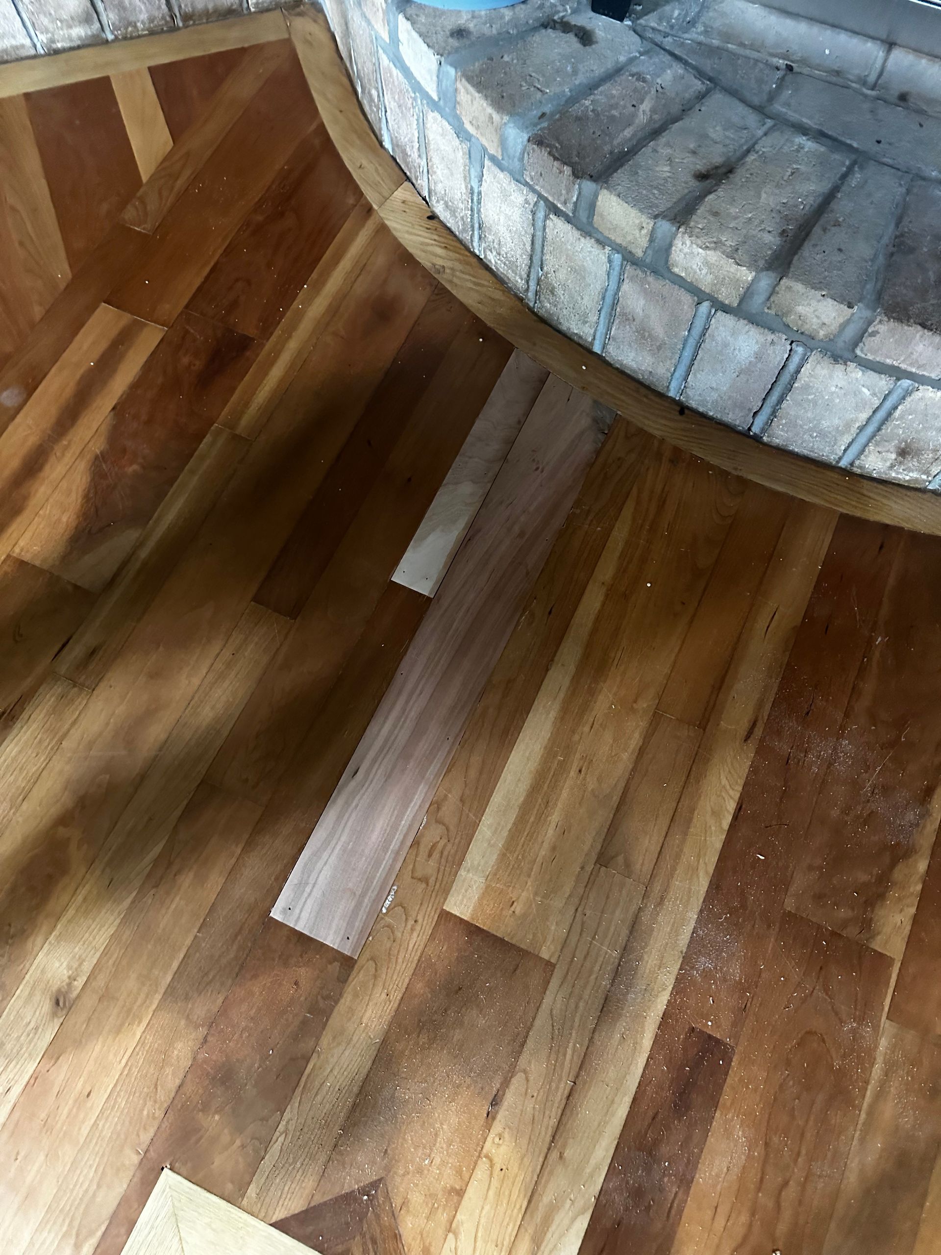 A wooden floor with a fireplace in the background