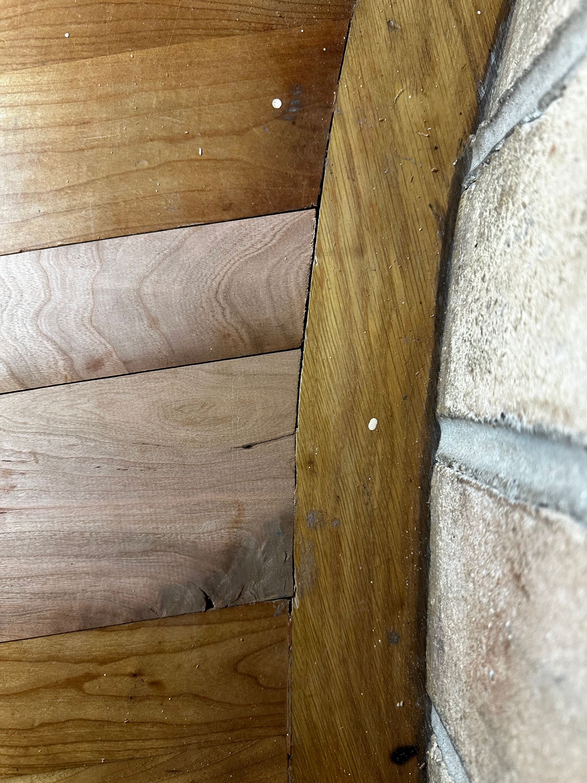 A close up of a wooden wall next to a brick wall.