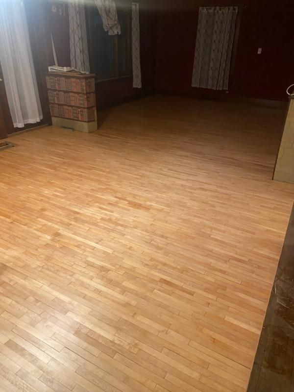 A living room with a wooden floor and a fireplace.