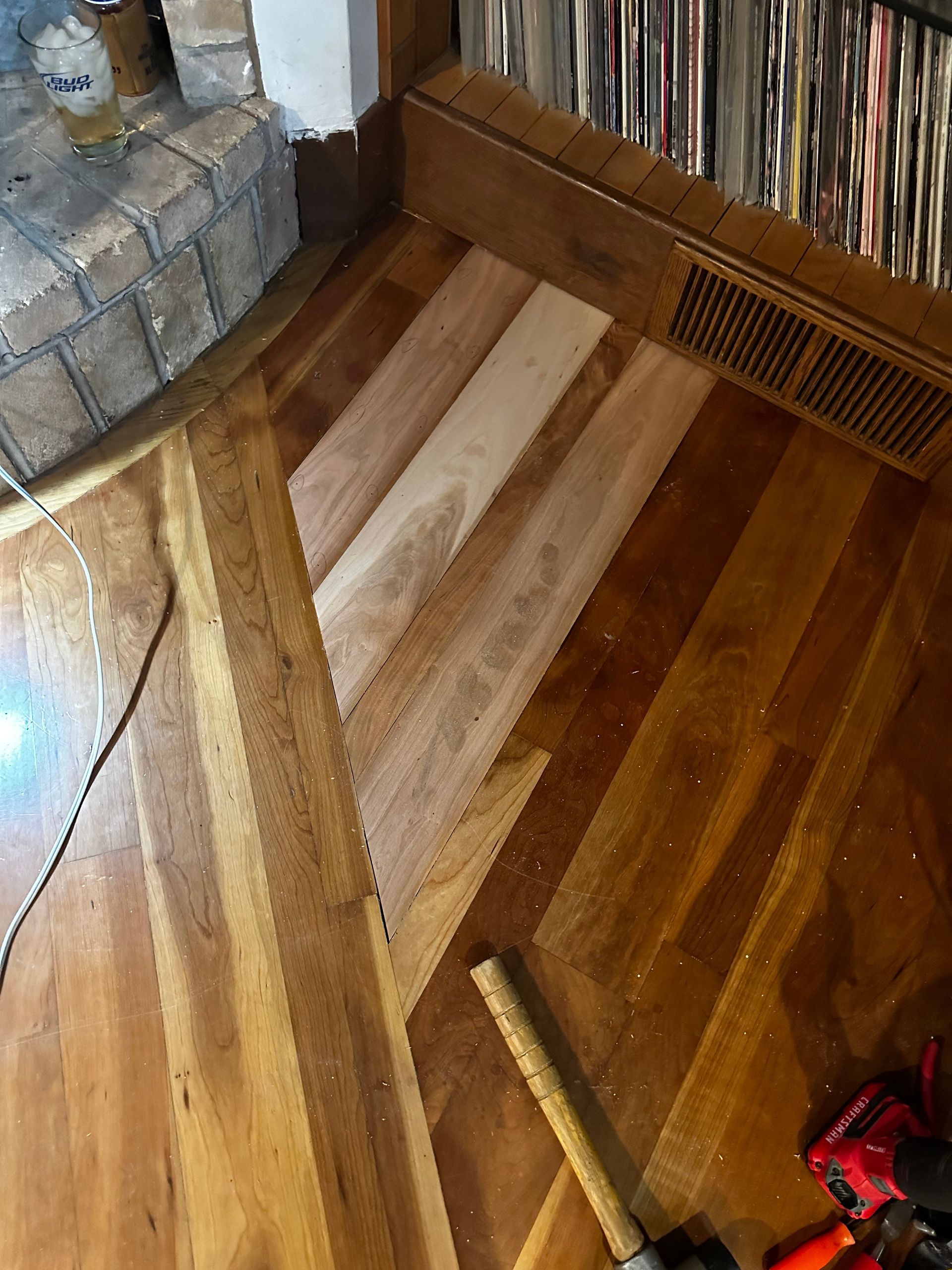 A wooden floor with a fireplace in the background.