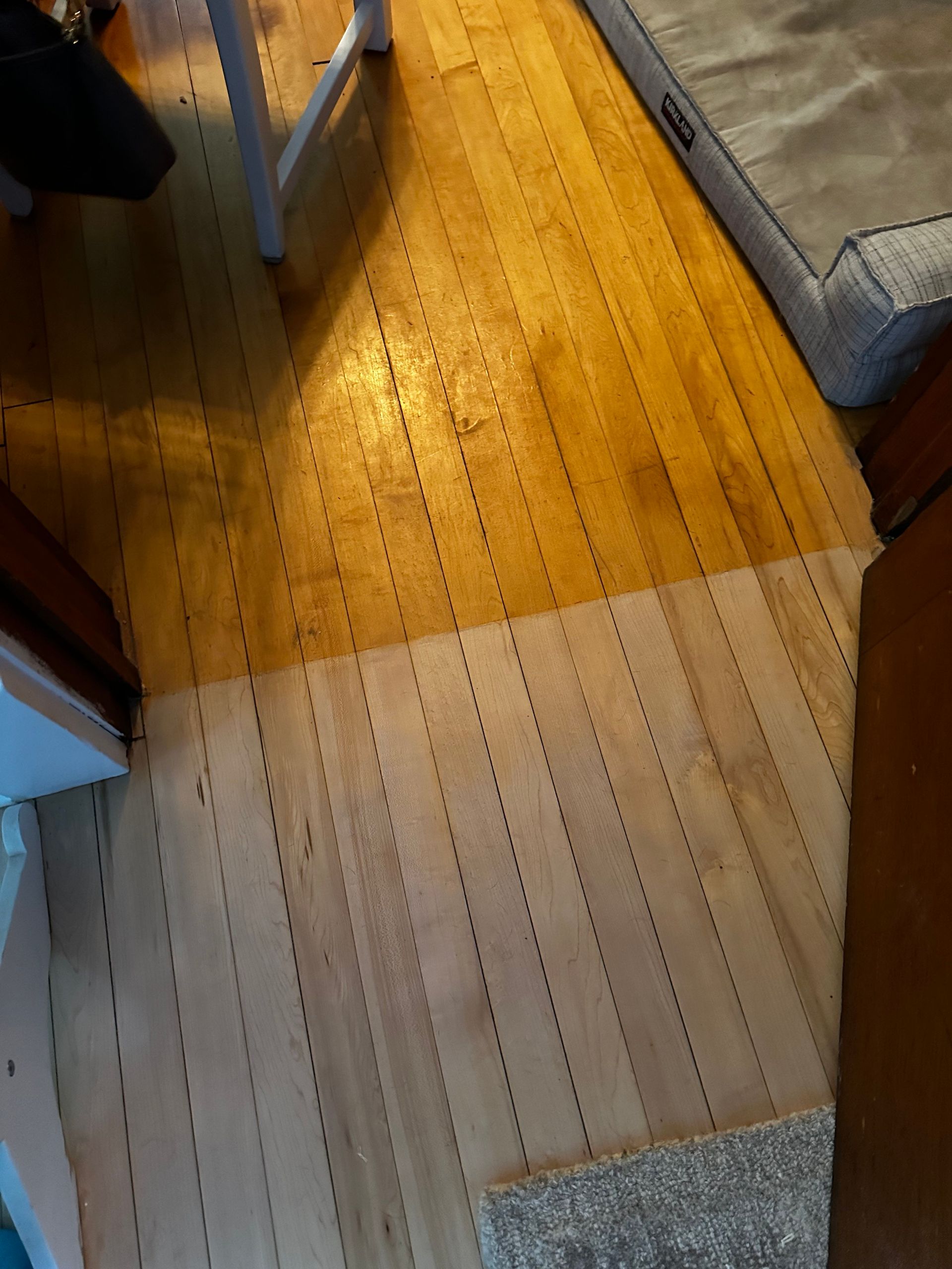 A wooden floor with a white rug on it