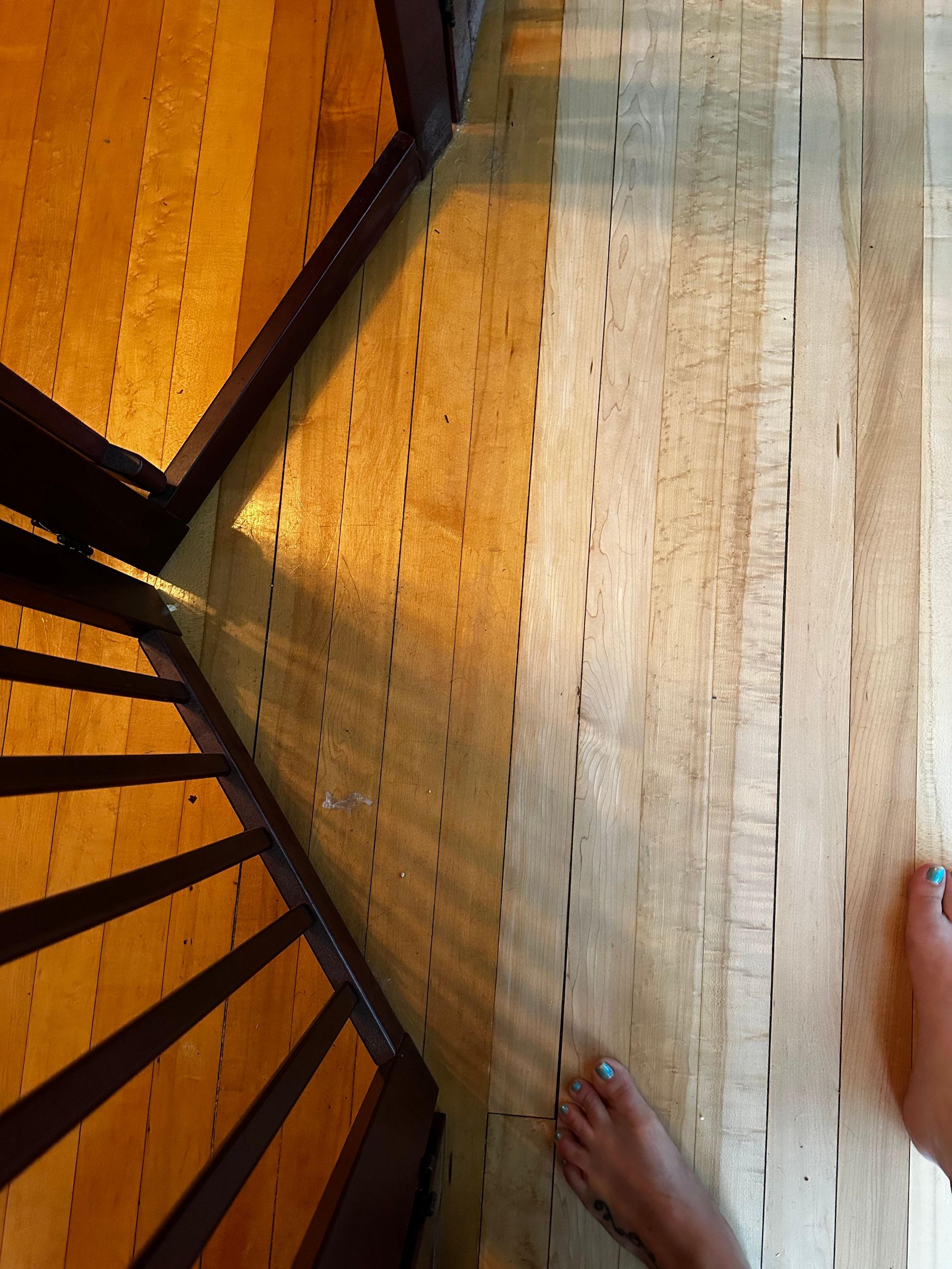 A person 's feet are visible in front of a spiral staircase