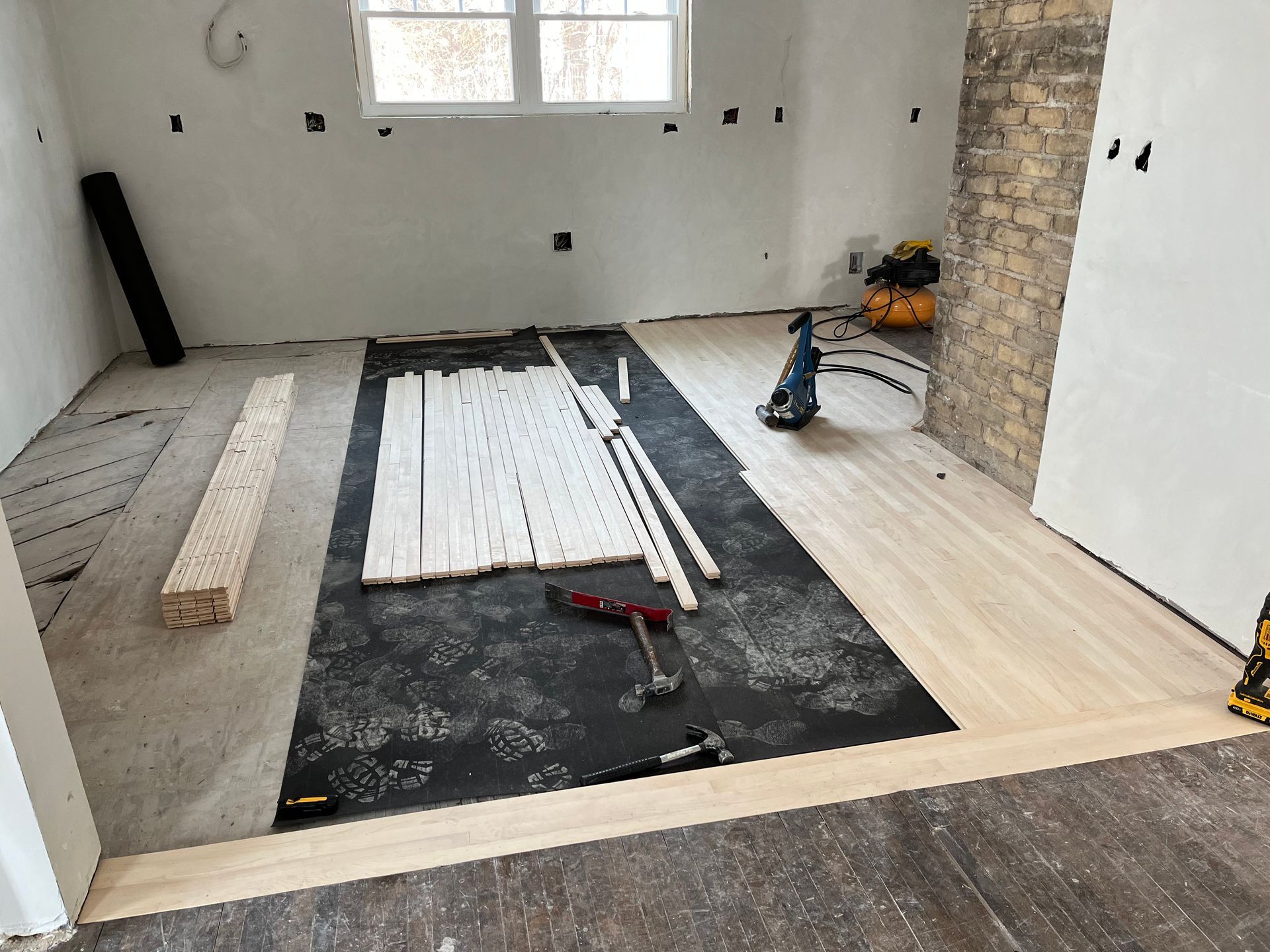 A wooden floor is being installed in a room.