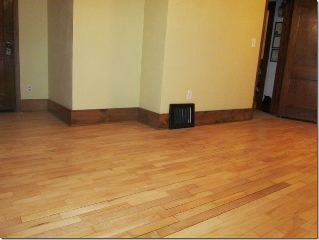 An empty room with hardwood floors and yellow walls