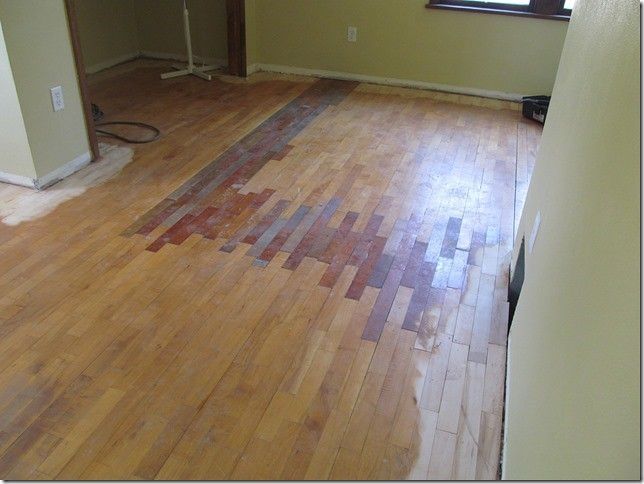A wooden floor is being painted in a room