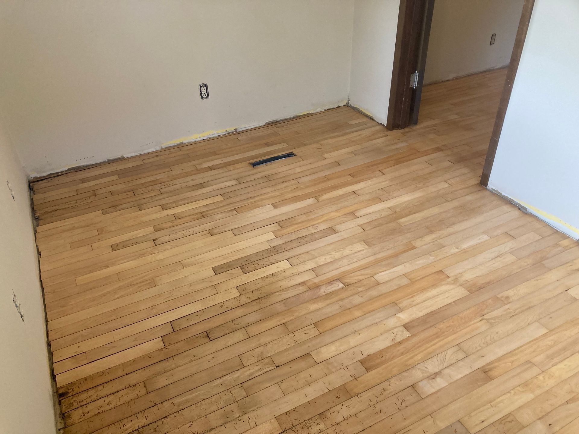 A room with a wooden floor and a door.