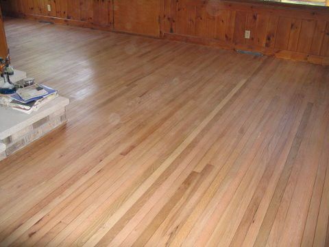 A living room with a wooden floor and a fireplace.