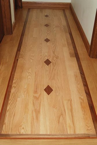 A hallway with a wooden floor and a wooden border.
