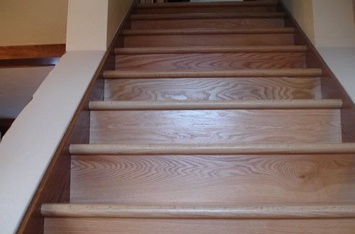 A set of wooden stairs with a white railing