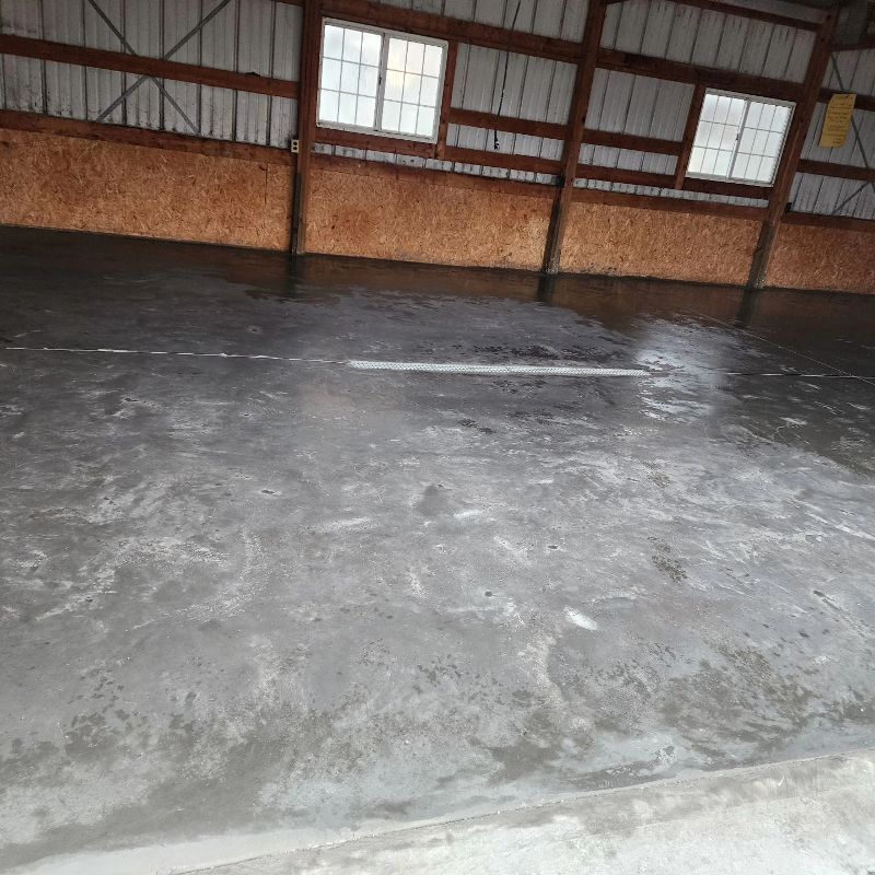 A concrete floor in a building with a lot of windows
