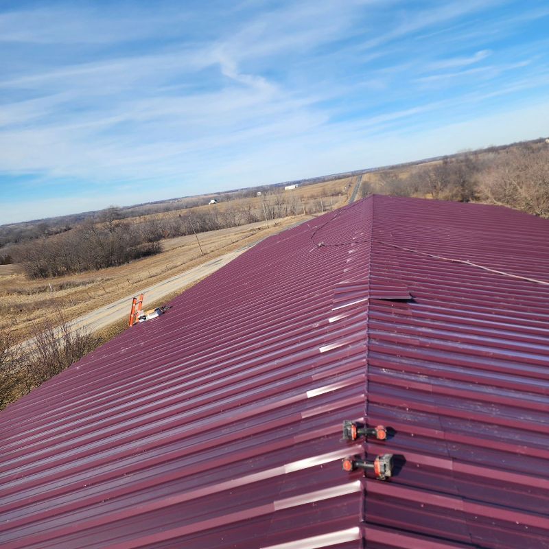 A purple metal roof with a blue sky in the background
