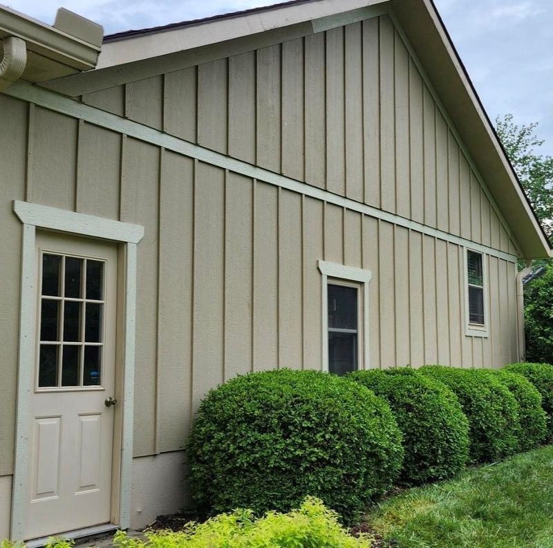 A beige house with a white door and windows