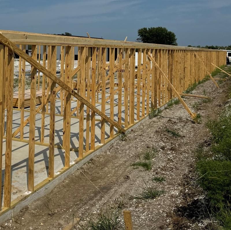 A wooden fence is being built in a field