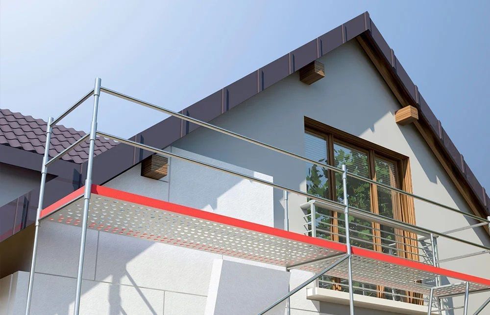 A house is being remodeled with scaffolding on the side of it.