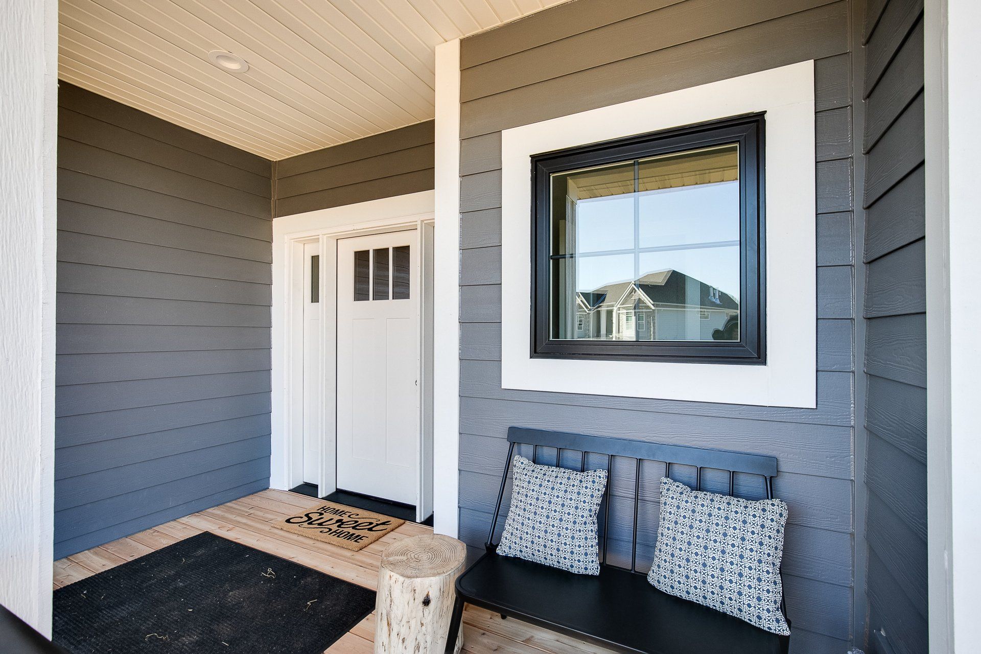 A black and white porch with a bench and a window