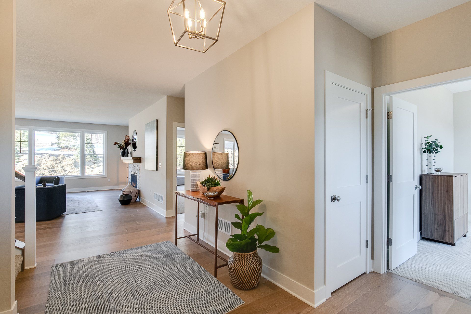 A hallway in a house with a table and a plant.
