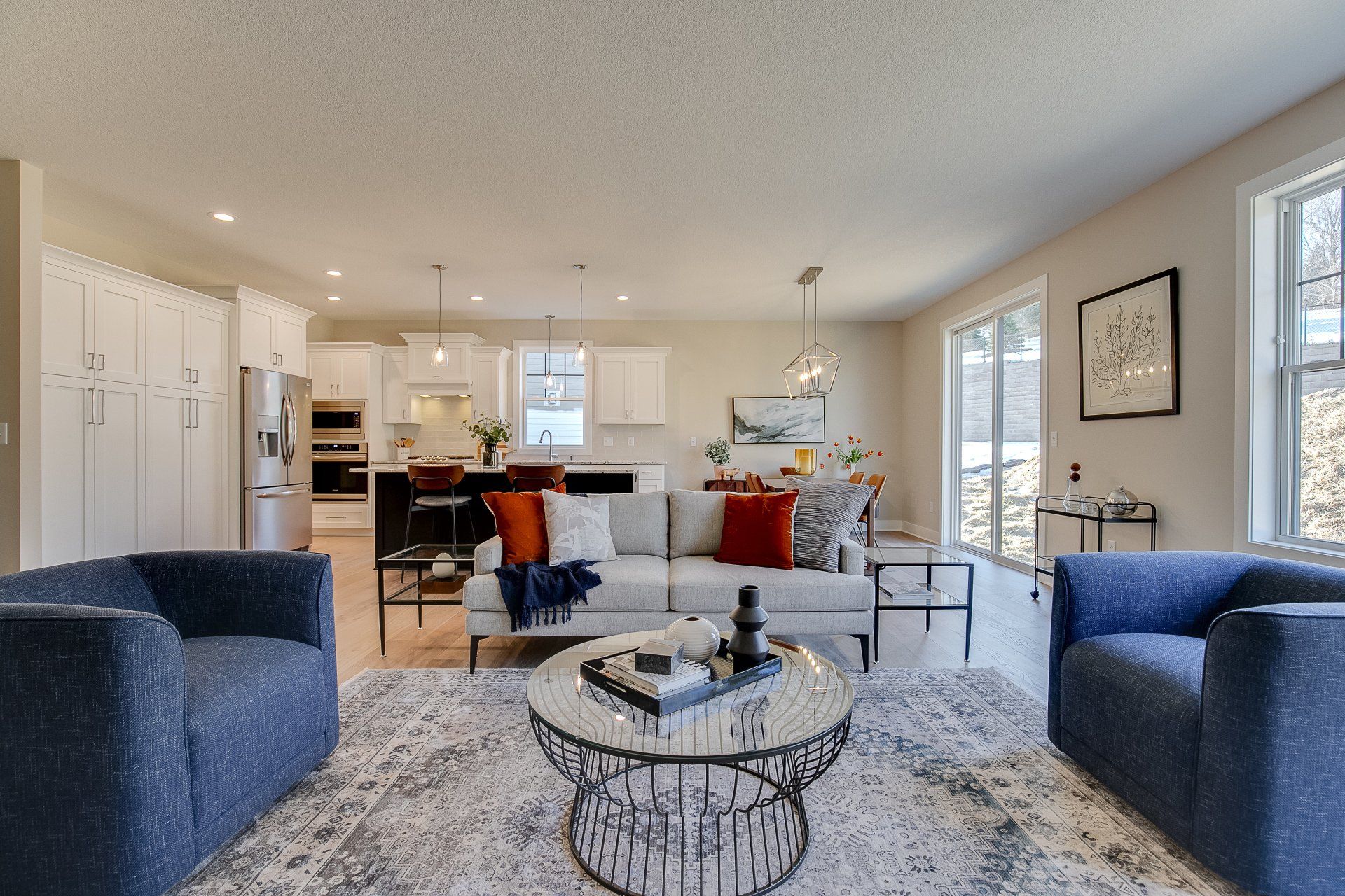 A living room with a couch, two chairs, a coffee table, and a rug.