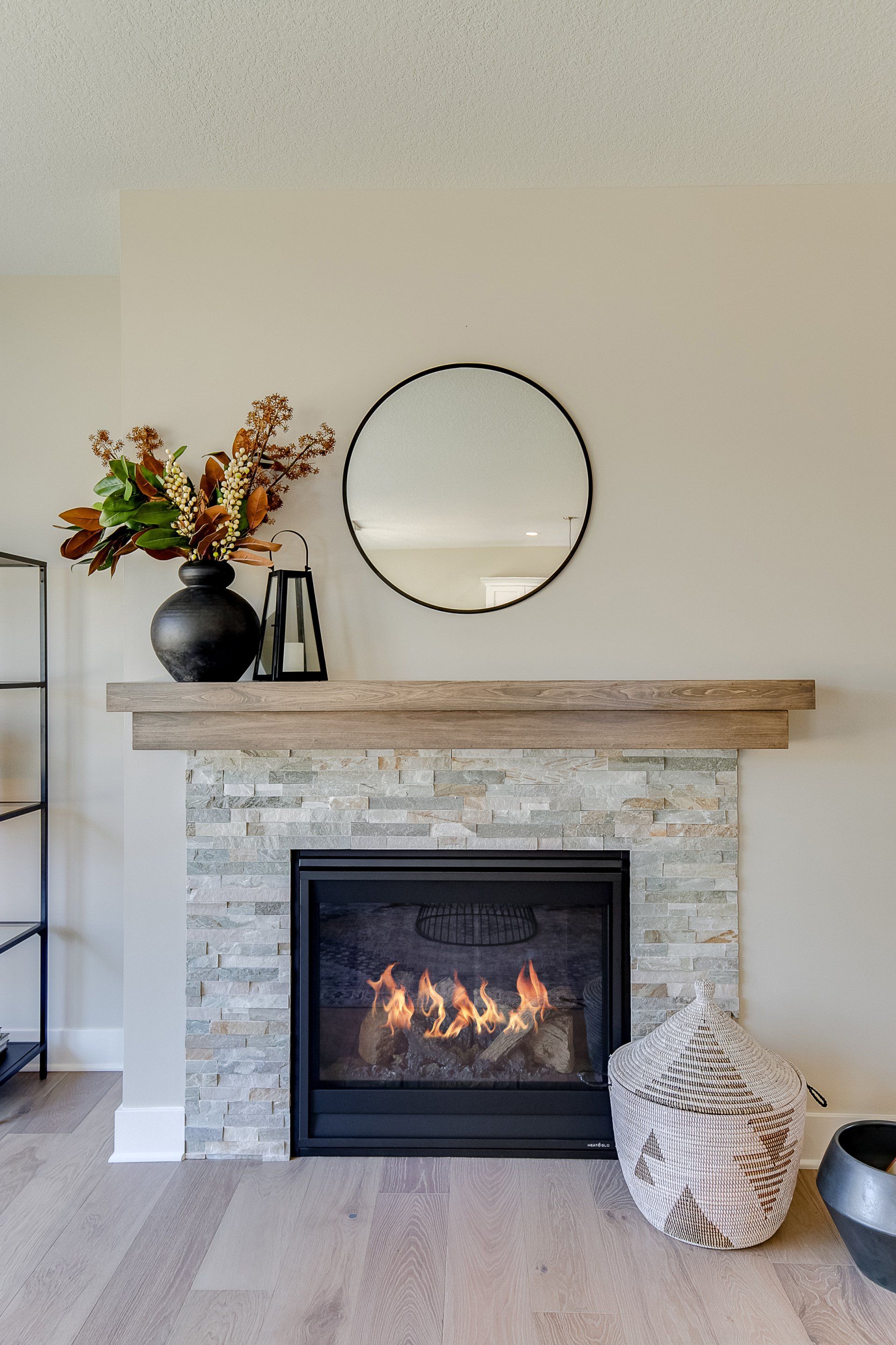 A living room with a fireplace and a mirror on the wall.