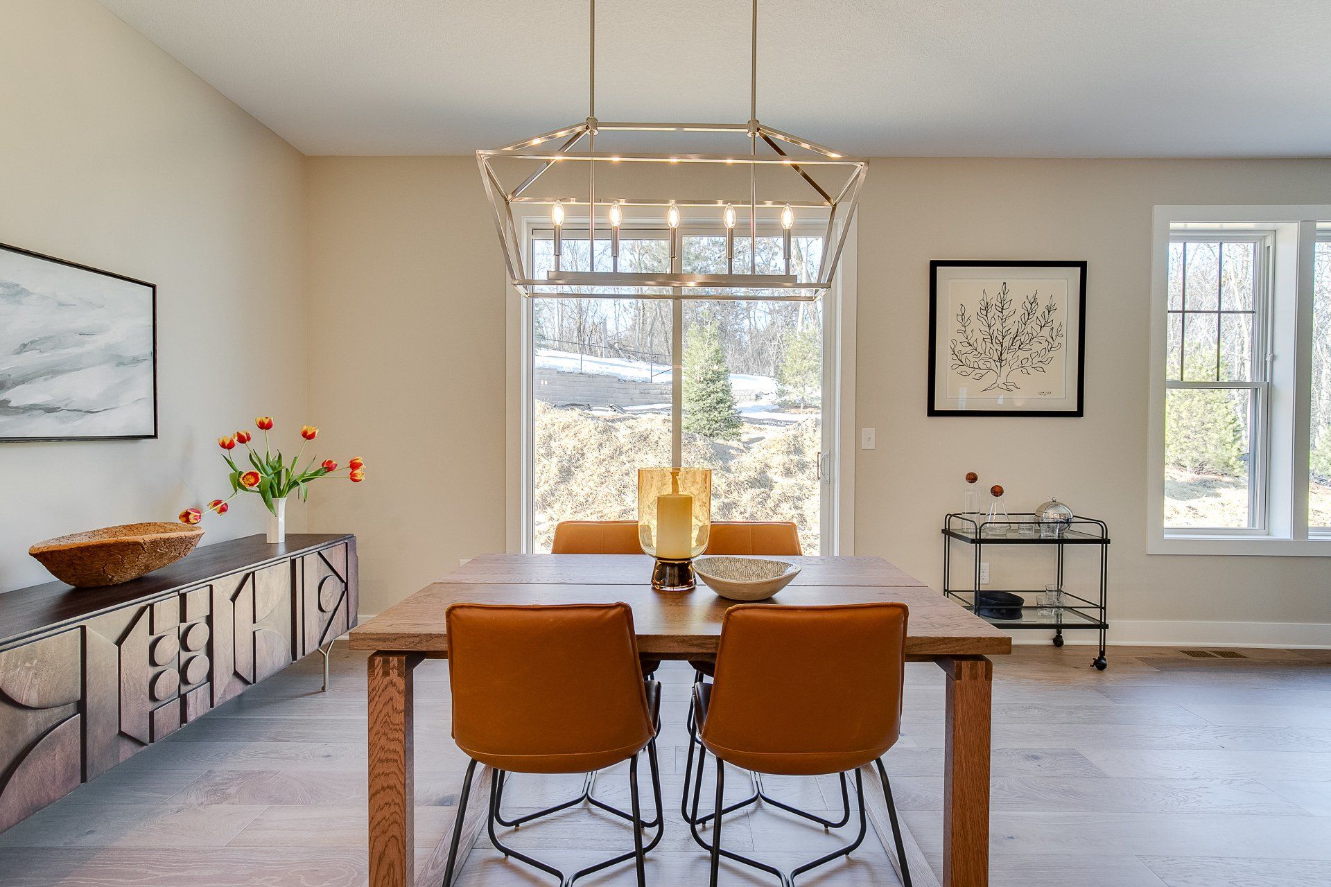 A dining room with a wooden table and chairs and a chandelier.