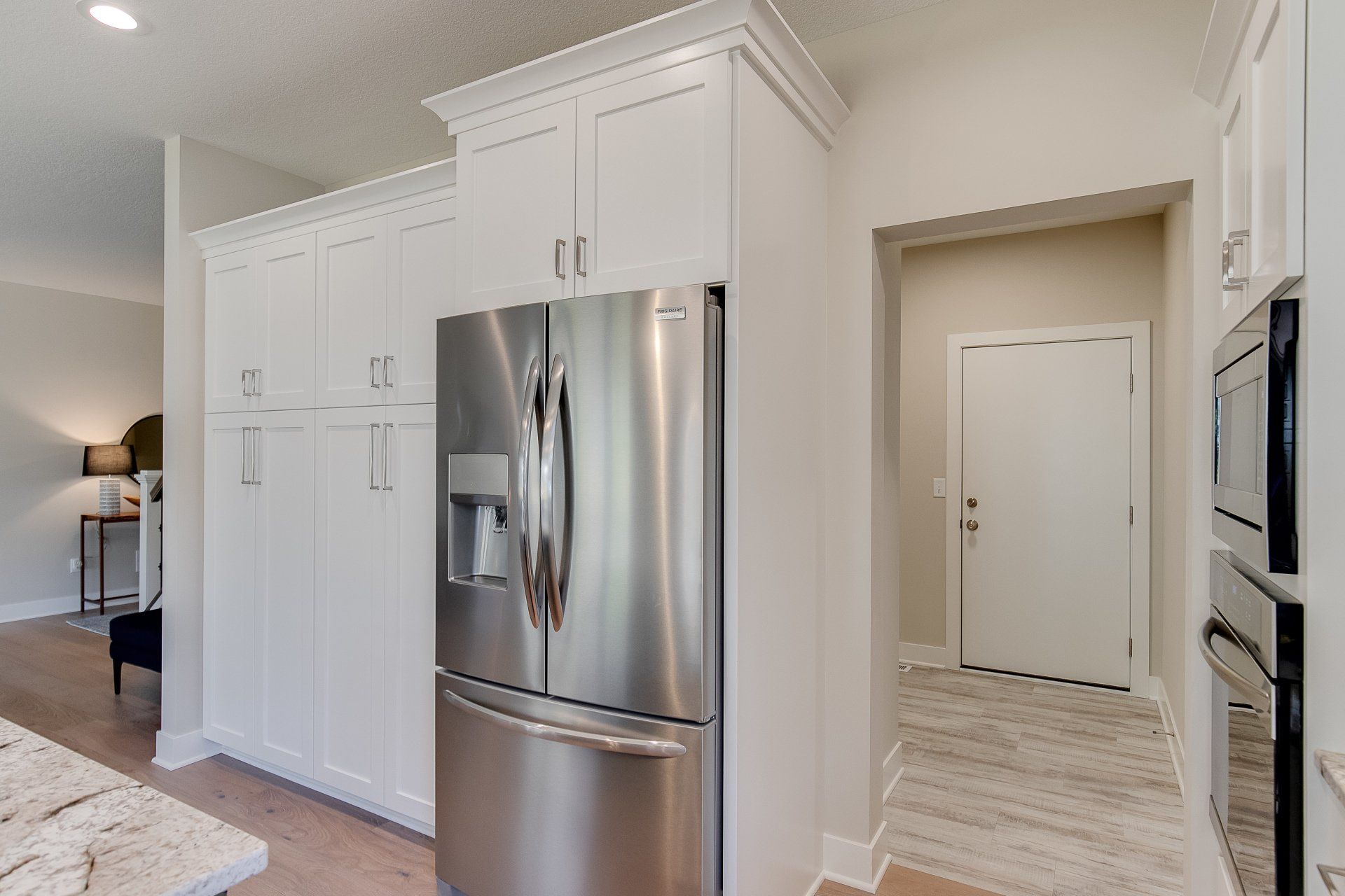 A kitchen with stainless steel appliances and white cabinets.